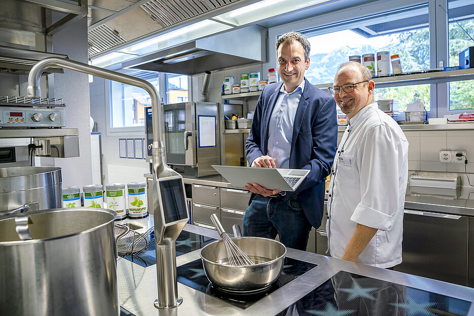 Adrian Seeholzer, responsable régional des ventes de Menu System, explique au chef Patrick Weber comment les mises à jour automatiques et la reconnaissance des poêles permettent de maintenir les performances de la cuisinière à un niveau toujours plus élevé.