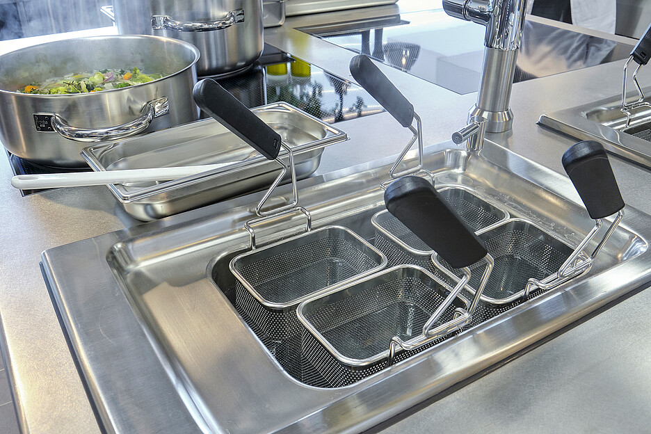 Au centre de la cuisine se trouve le bloc de cuisson modulaire, conçu spécialement pour l’EHL par Electrolux Professional, avec induction, wok, grill, friteuse, fry top (en acier chromé) et d‘un double cuiseur à pâtes.