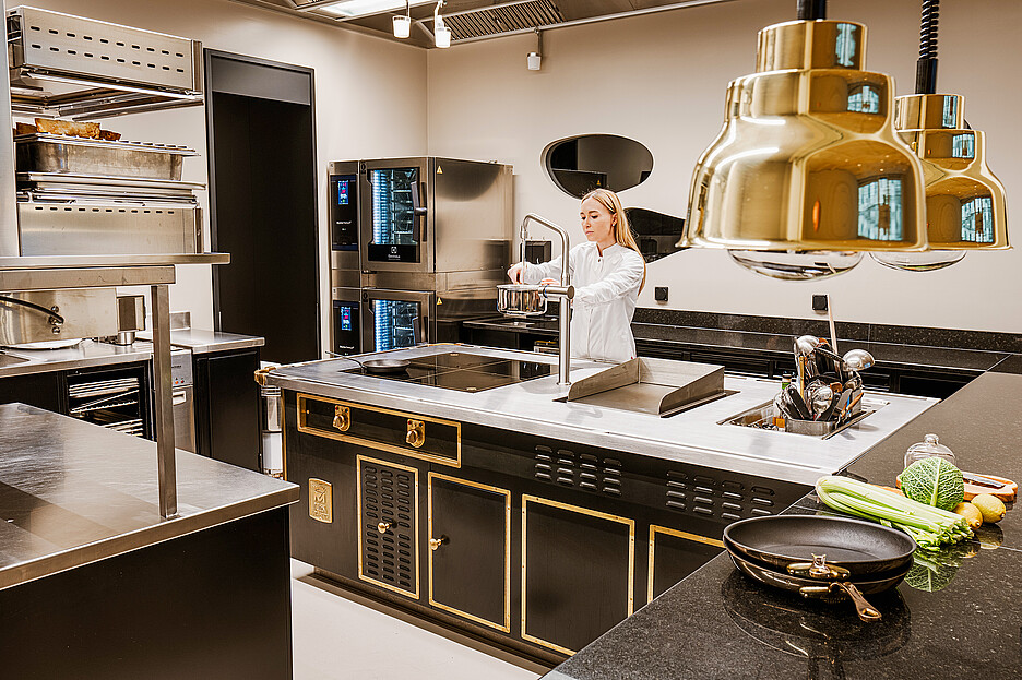 Le fourneau Molteni noir et or dʼElectrolux Professional avec les quatre plaques à induction intégrales et la plaque de gril constitue le cœur de la cuisine du CAAA.