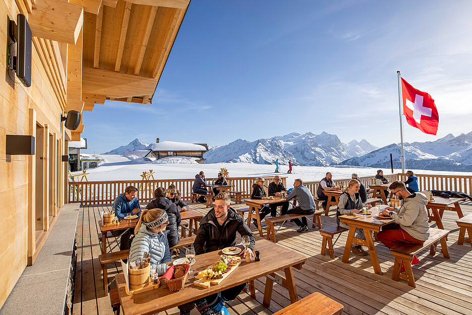 Une journée hivernale parfaite: du soleil, de la neige et une terrasse ensoleillée avec vue magnifique au loin et de nombreux délices dans l’assiette.
