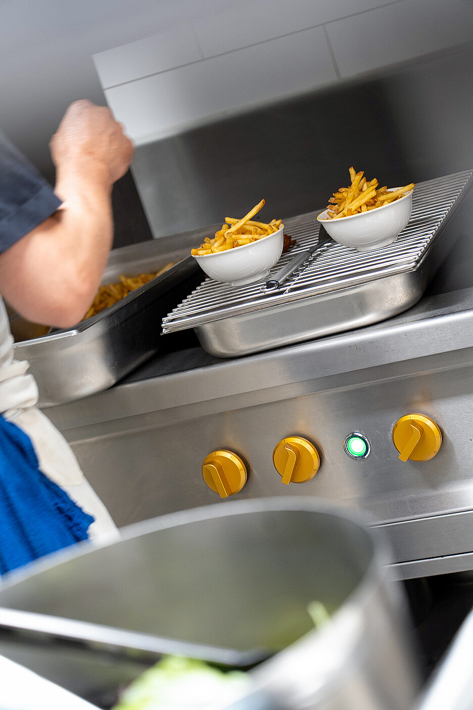 Servies sur un grand plateau – au préalable, les frites restent chaudes et croustillantes pendant un court moment dans des barquettes préchauffées sous un pont thermique.